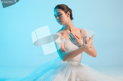 Image of Young and incredibly beautiful ballerina is dancing in a blue studio