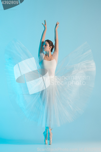 Image of Young and incredibly beautiful ballerina is dancing in a blue studio