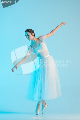 Image of Young and incredibly beautiful ballerina is dancing in a blue studio