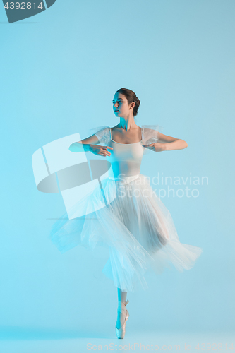 Image of Young and incredibly beautiful ballerina is dancing in a blue studio