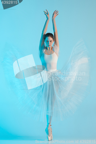 Image of Young and incredibly beautiful ballerina is dancing in a blue studio