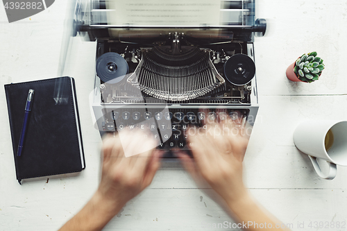 Image of Writer typing with retro writing machine.