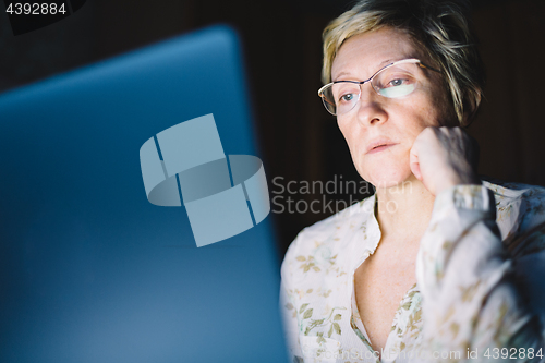 Image of Middle-aged woman working on laptop