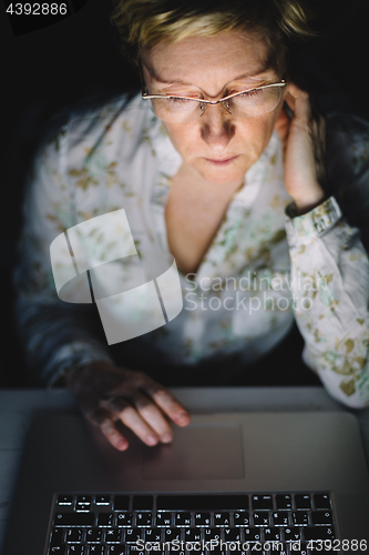 Image of Middle-aged woman working on laptop