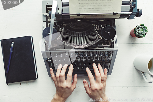 Image of Writer typing with retro writing machine.