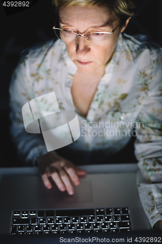 Image of Middle-aged woman working on laptop