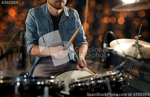 Image of male musician playing drum kit at concert