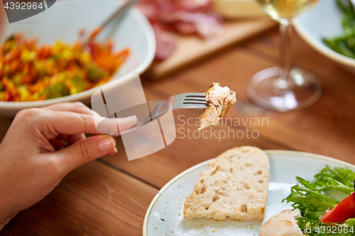 Image of hand with chicken meat on fork