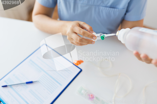 Image of close up of nurse preparing drop counter