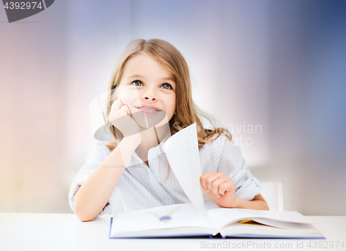 Image of happy smiling student girl reading book