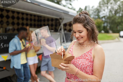 Image of happy woman with wok and friends at food truck