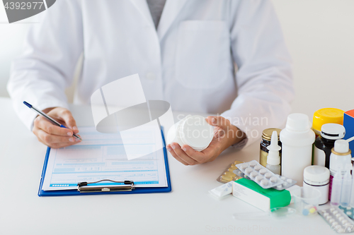 Image of doctor with medicines and clipboard at hospital