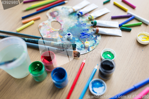 Image of color palette, brushes and paint tubes on table