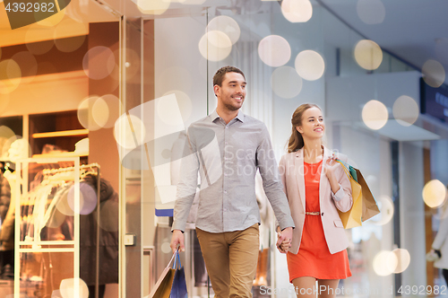 Image of happy young couple with shopping bags in mall