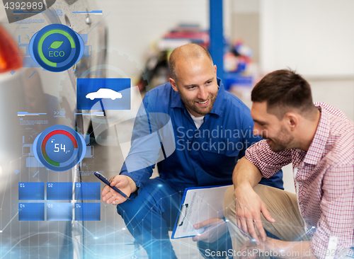 Image of auto mechanic with clipboard and man at car shop