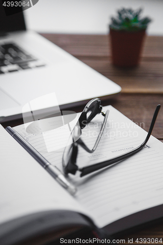 Image of Working place with laptop on wooden table