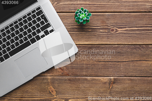 Image of Working place with laptop on wooden table