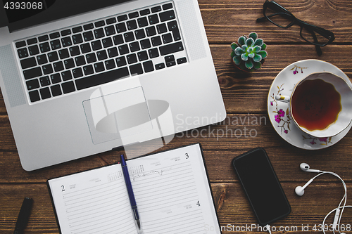 Image of Working place with laptop on wooden table