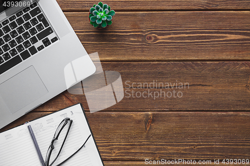 Image of Working place with laptop on wooden table