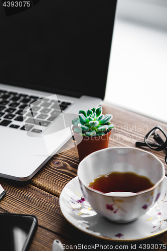 Image of Working place with laptop on wooden table