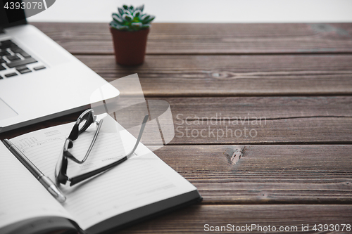 Image of Working place with laptop on wooden table