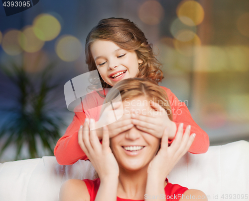 Image of happy mother and daughter playing at home