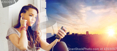 Image of teenage girl with smartphone and earphones