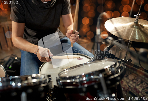 Image of male musician playing drum kit at concert