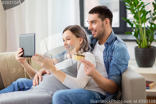 Image of man and pregnant wife shopping online at home