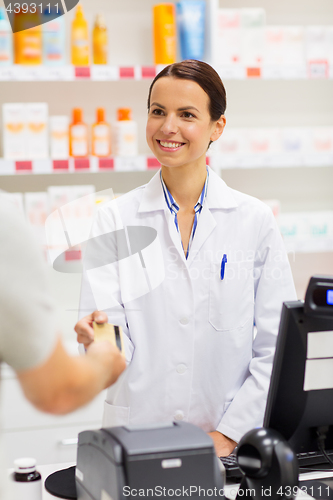 Image of apothecary taking credit card at pharmacy cashbox