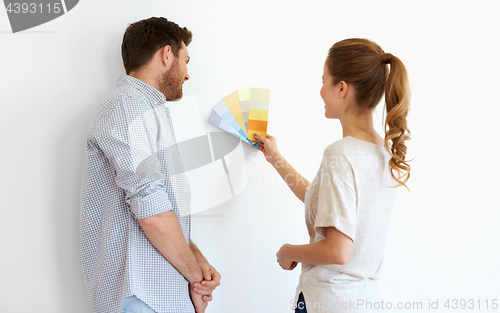 Image of happy couple with color samples at new home