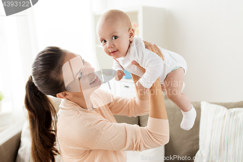 Image of happy mother playing with little baby boy at home