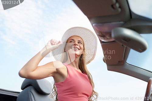 Image of happy young woman in convertible car