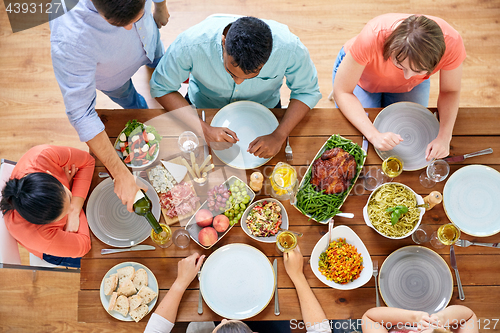 Image of group of people eating at table with food