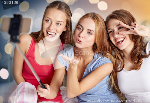 Image of teen girls with smartphone taking selfie at home