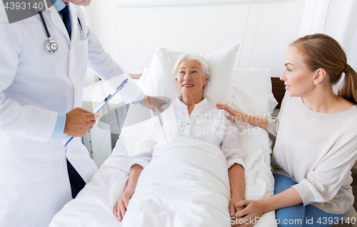 Image of senior woman and doctor with clipboard at hospital