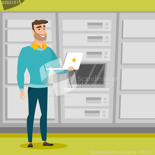 Image of Engineer working on laptop in network server room.