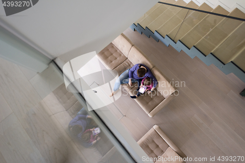 Image of mother and her cute little daughter are using a tablet top view