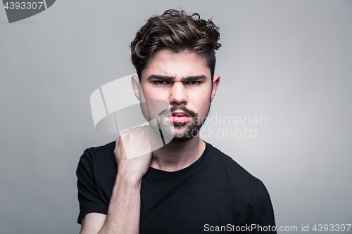 Image of Young handsome man doubting on gray background 