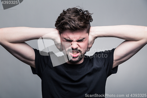 Image of I need silence. Frustrated young man in shirt 