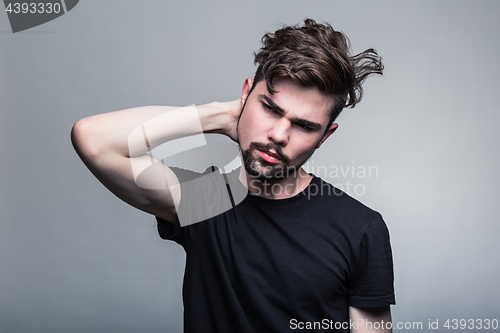 Image of Young handsome man doubting on gray background 