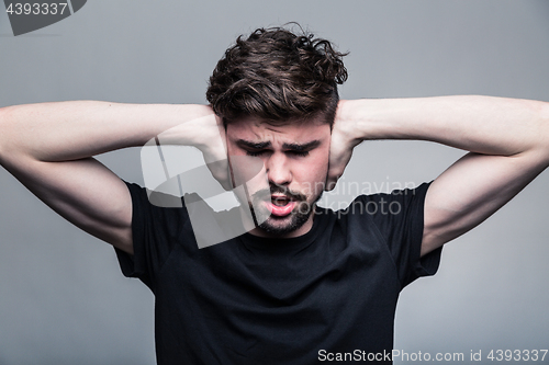 Image of I need silence. Frustrated young man in shirt 