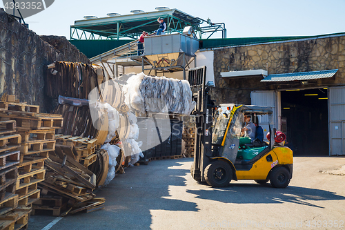 Image of Forklift operator handling wooden pallets in warehouse