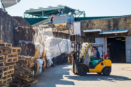 Image of Forklift operator handling wooden pallets in warehouse