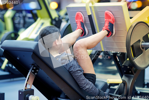 Image of woman flexing muscles on leg press machine in gym