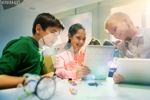 Image of kids with tablet pc programming at robotics school