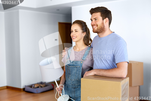 Image of couple with boxes and lamp moving to new home