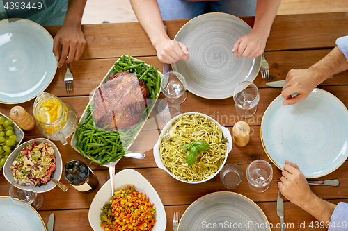 Image of group of people with chicken and pasta on table