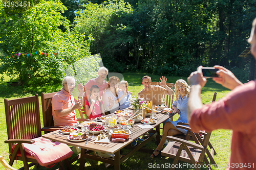 Image of happy family photographing by smartphone in summer