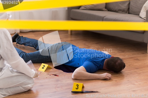 Image of criminalist collecting evidence at crime scene